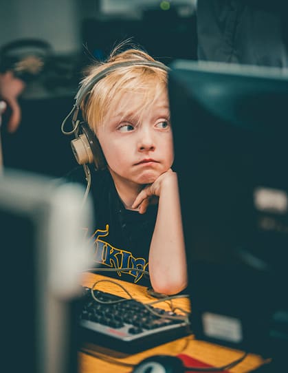 photo of boy wearing headphone